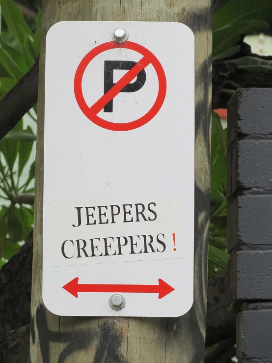 a sign attached to a wooden pole with trees in the background