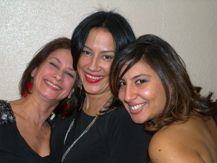 three ladies smiling for a picture on the bed