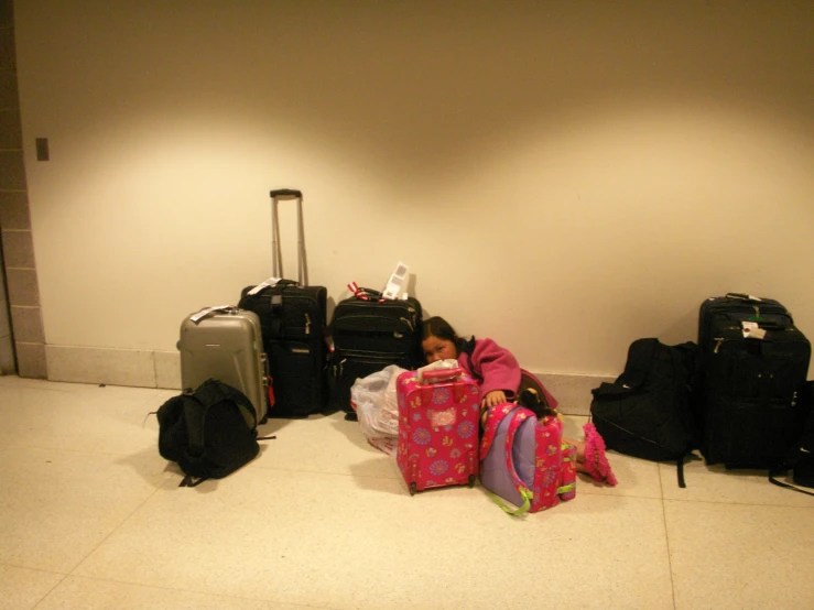 several suitcases and one girl lying on the floor