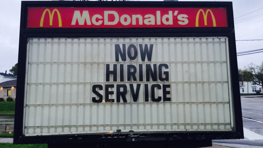 a mcdonald's sign reading now hiring service