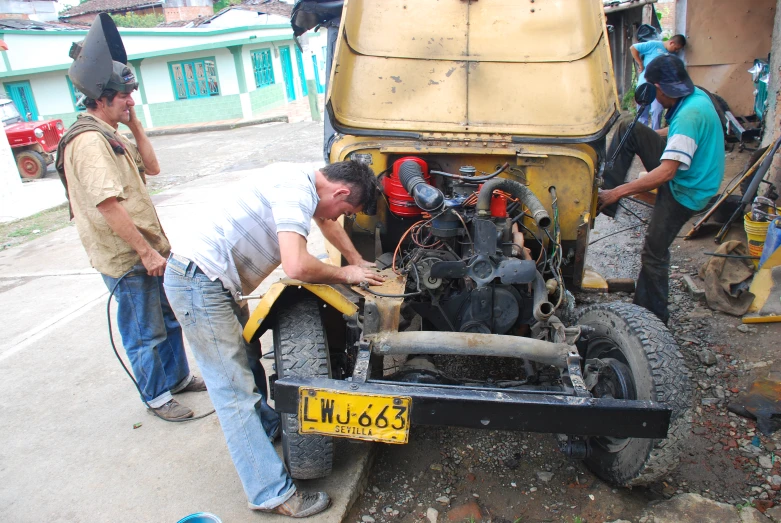 a group of men working on some type of vehicle