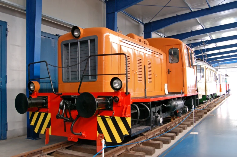 a large train sits on the tracks in a station