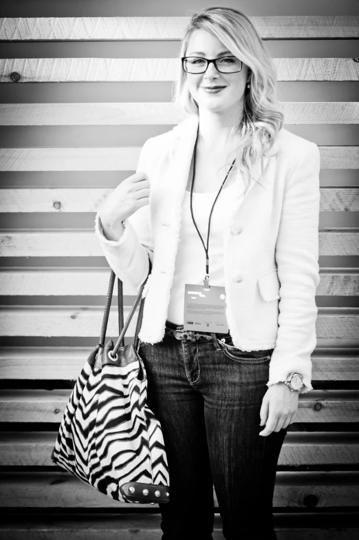 woman holding a handbag and purse standing in front of an artistic striped wall