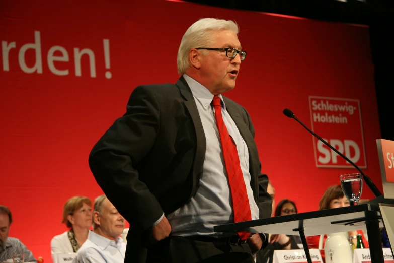 a man in a suit speaking to a crowd