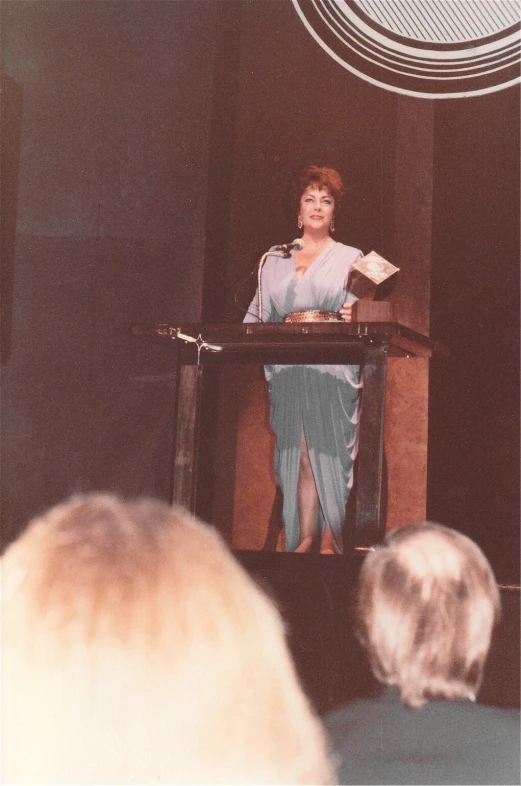 an image of a woman speaking at a podium