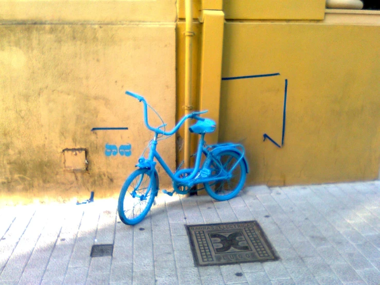 a blue bike is leaning against a wall