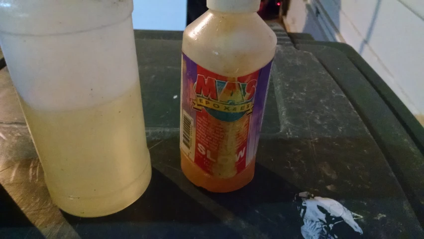 an orange drink is next to a bottle with a lid