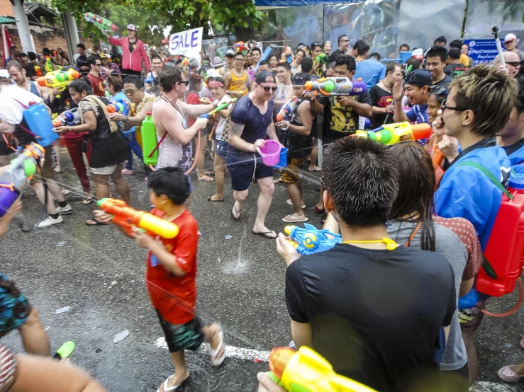 a crowd of people with colorful body paint and inflatable guns