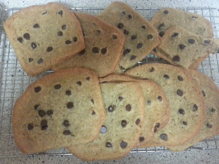 a bunch of chocolate chip cookies are cooling on the rack