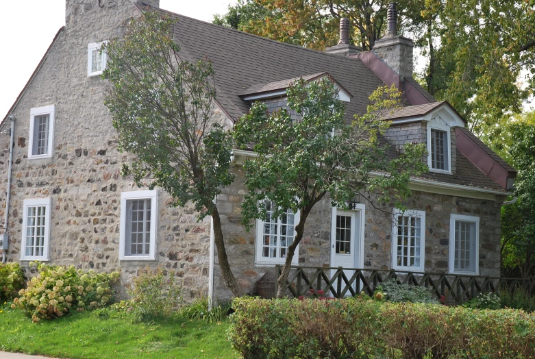 the stone house has a large tower with white shutters