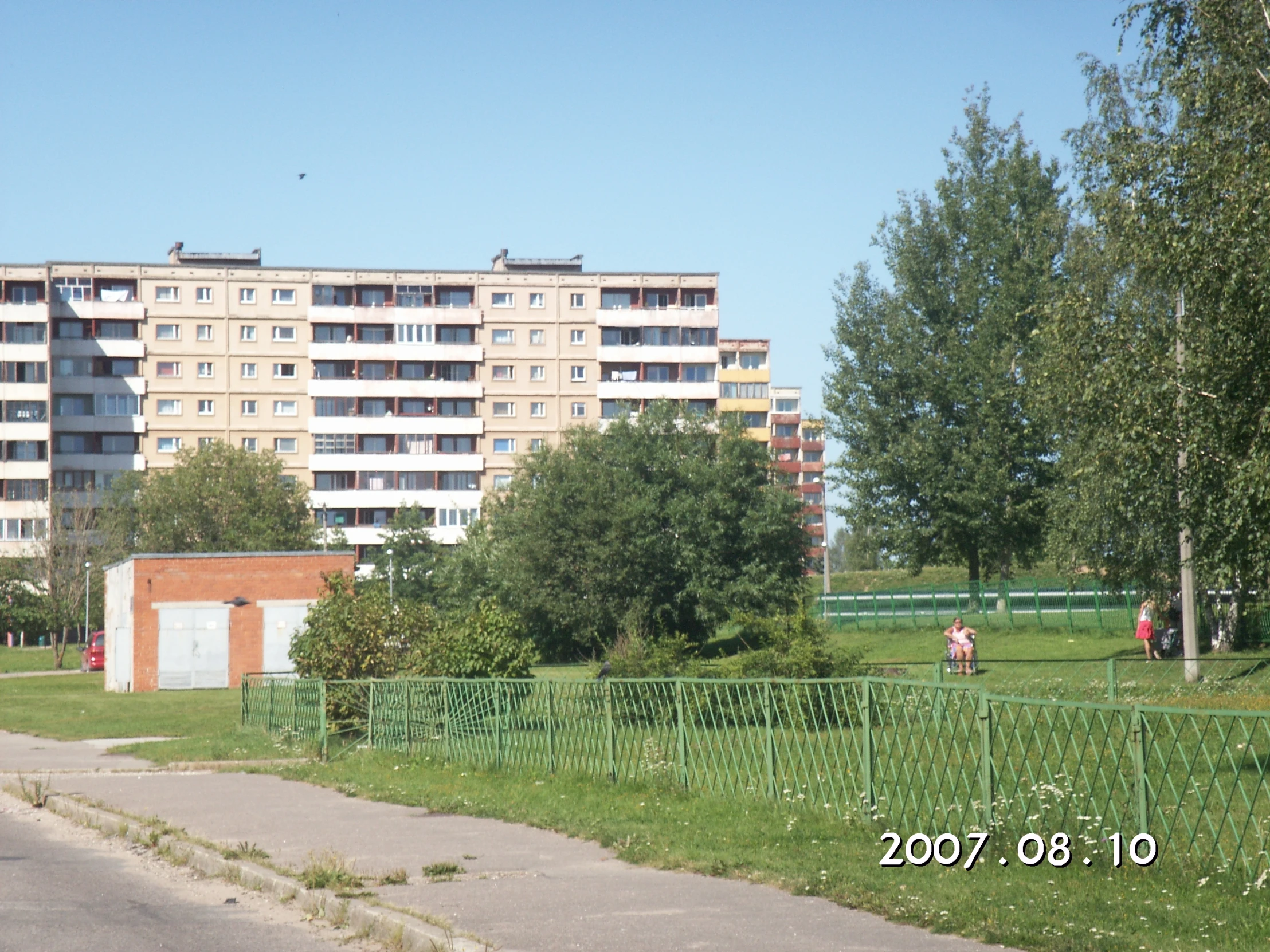 a large apartment building on the side of a grassy hill