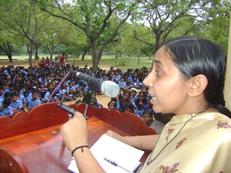 a woman holding a microphone in front of a crowd of people