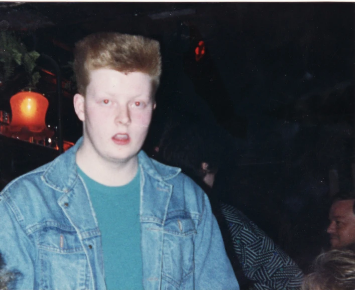 a boy standing in front of a crowd at a party