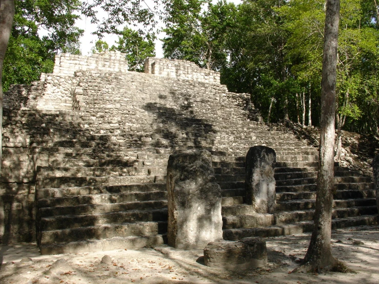 an ancient stone structure surrounded by trees and rocks