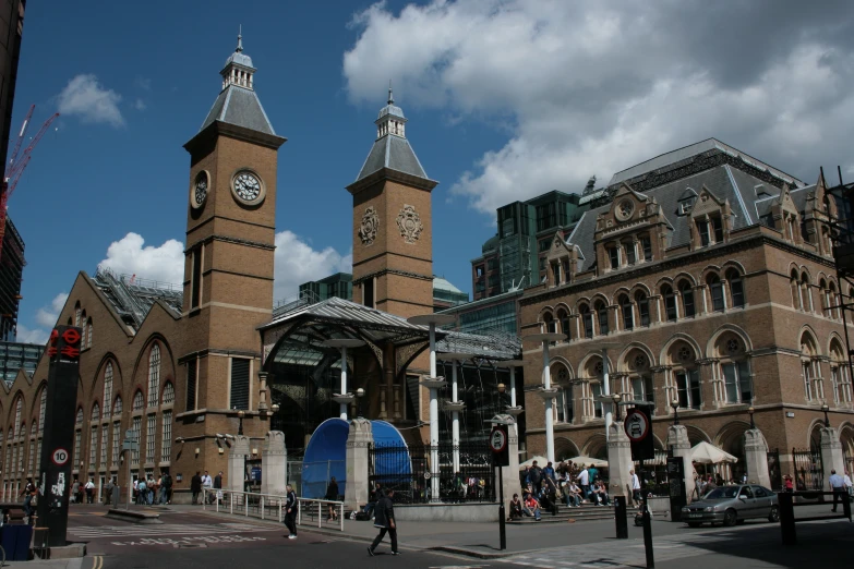 some tall buildings with clocks on them next to buildings