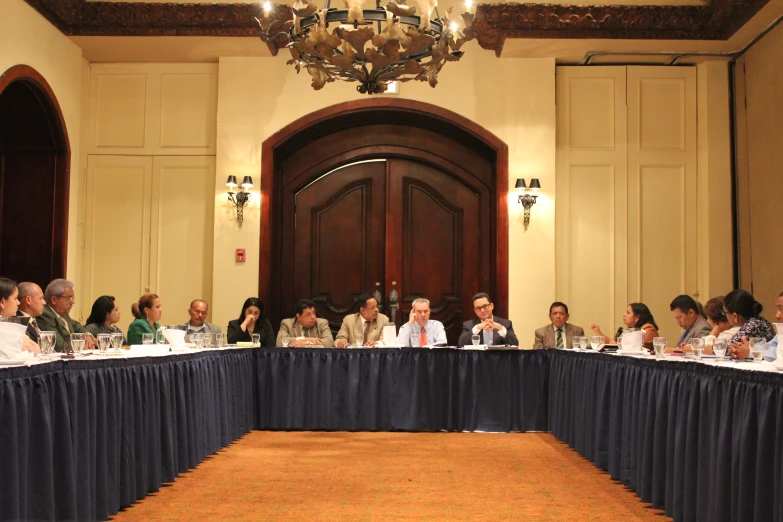 people are sitting at tables in a public meeting