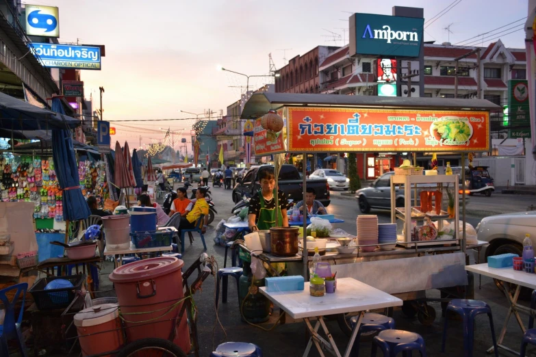 a city street is lined with shops with various stalls