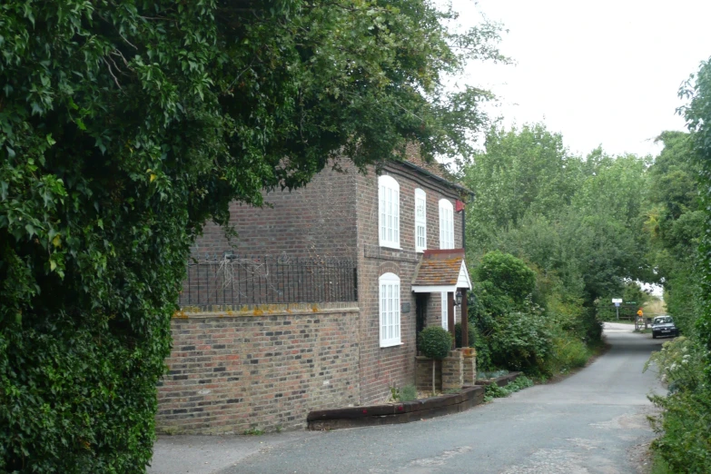 a street in the country side area with a house and a car parked