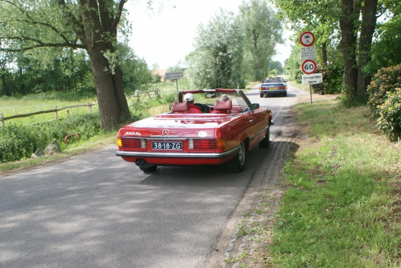 an convertible parked on the side of a road