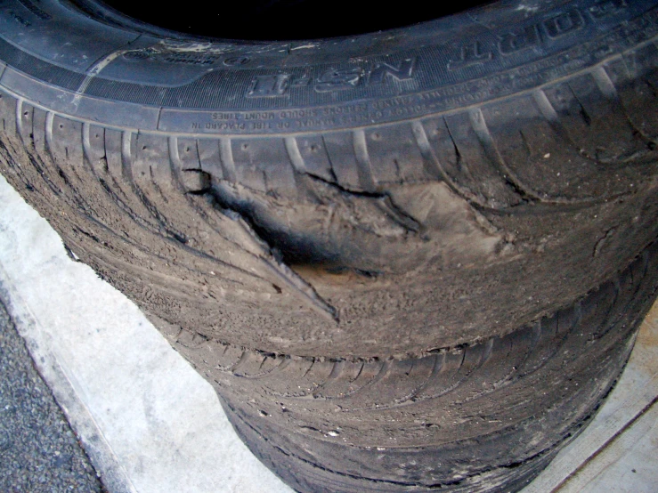 two tires with some dirt in them near a curb