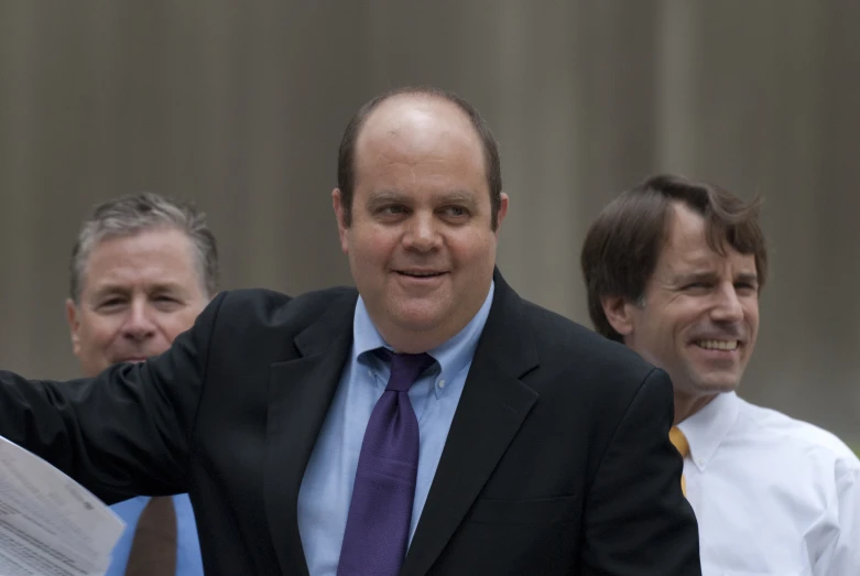 a group of men are standing together and smiling