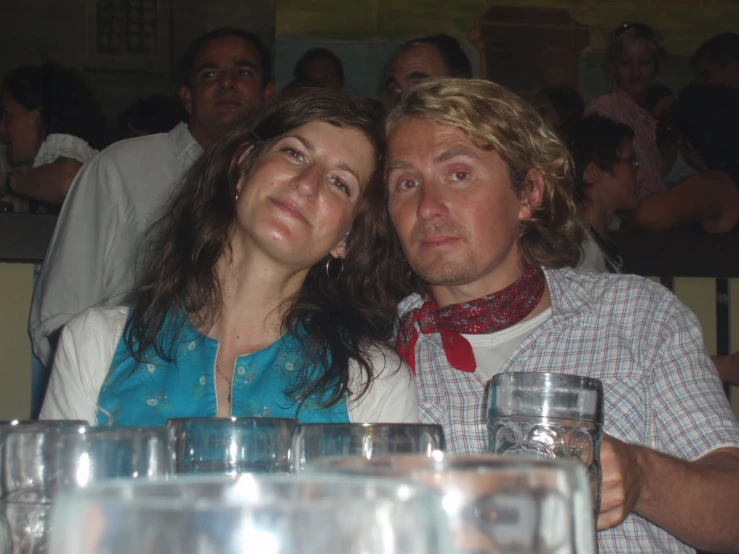 a couple is sitting at a bar drinking a beer