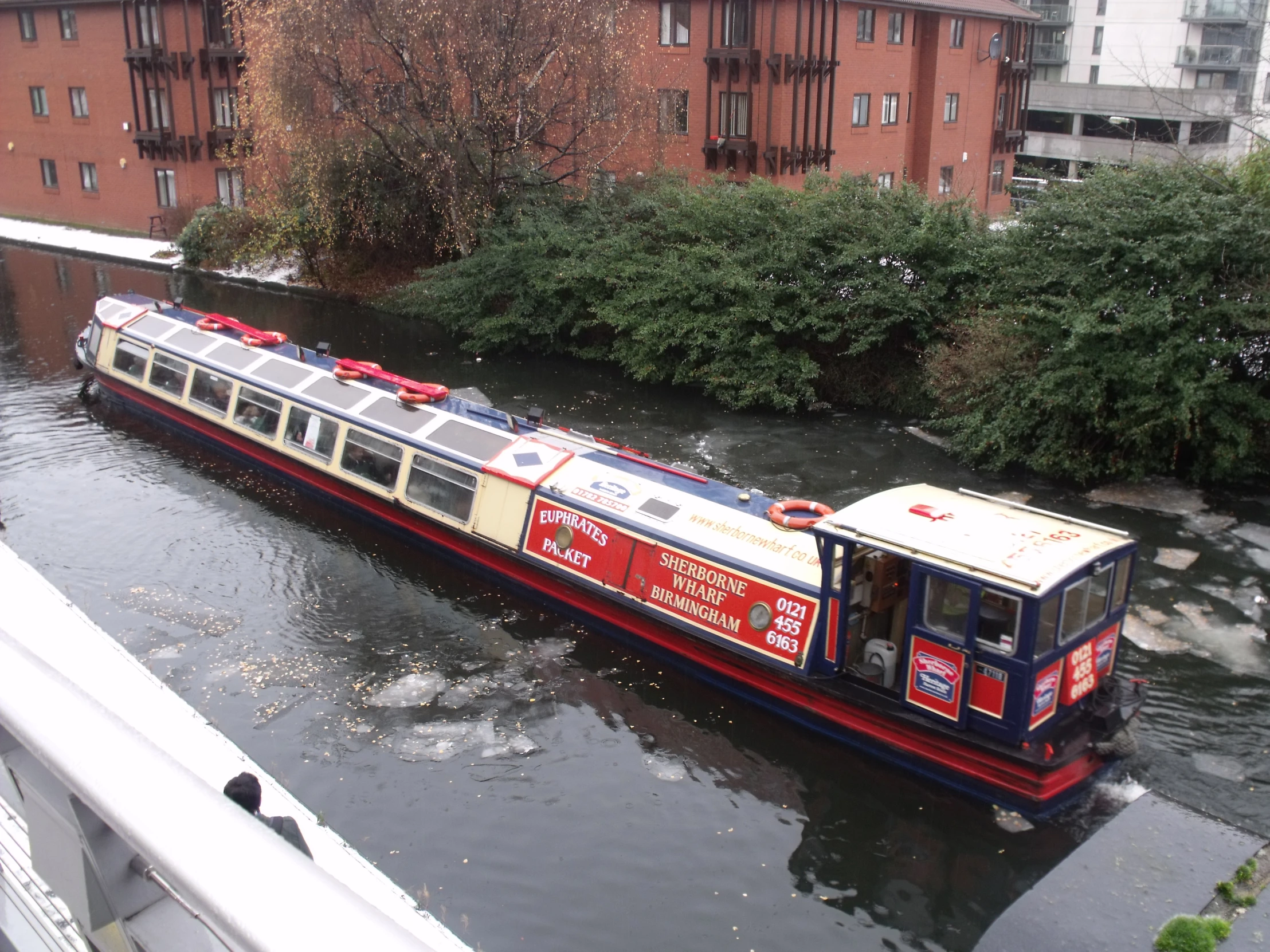 a long boat traveling along side of a river