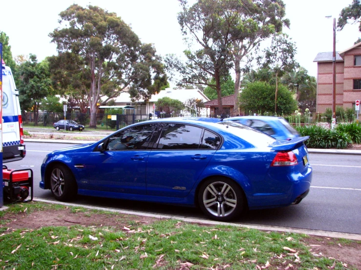 a blue and white car parked at the edge of a street