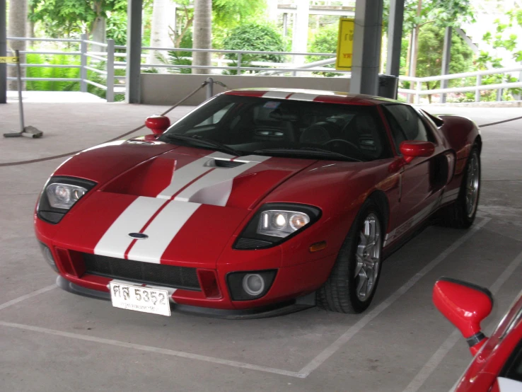 a red sports car with stripes parked inside of a building