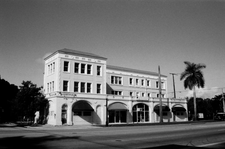 a tall white building sits on the corner of a street