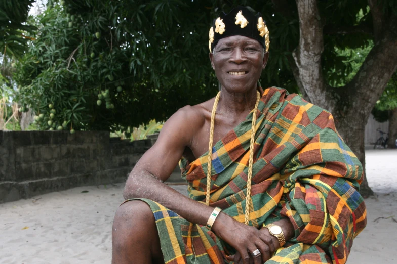 a black man is wearing a green and yellow blanket