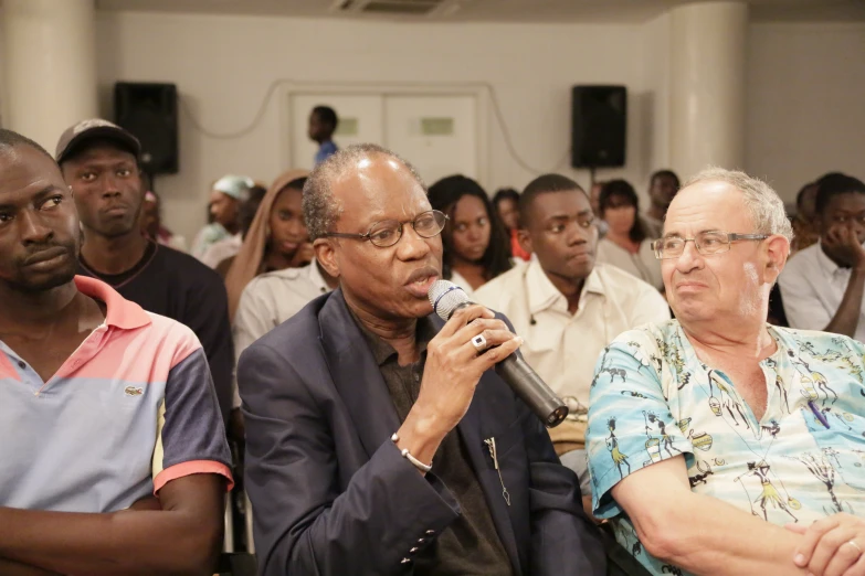 the group of men is sitting down listening