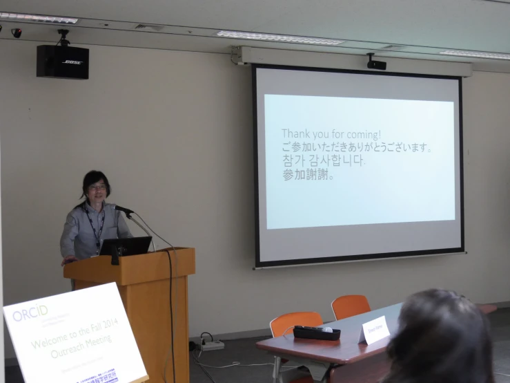 a woman is giving a presentation at a seminar