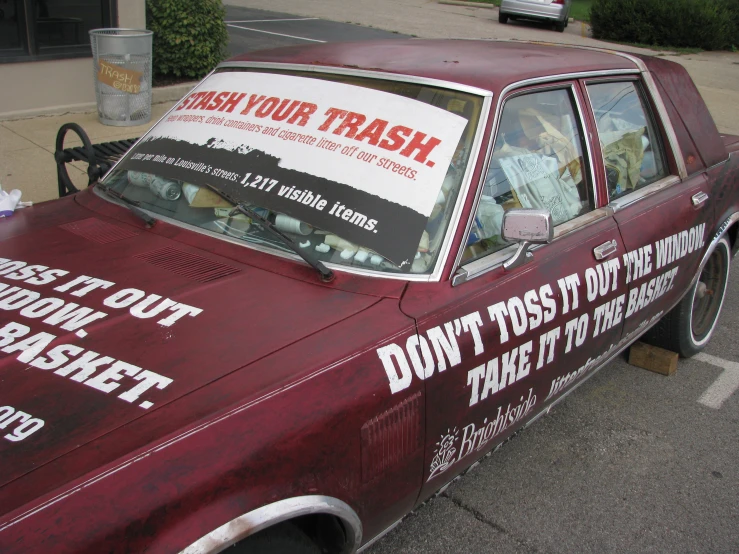 a car with advertits on it parked in a parking lot