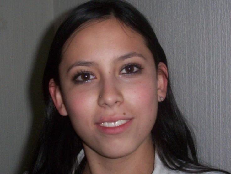 young woman with a white shirt smiling at the camera