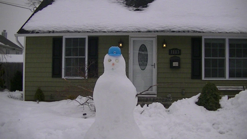 a snow man is standing outside of the house