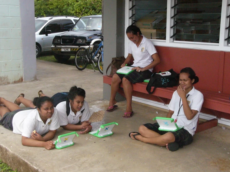 five girls on a porch with their laptops