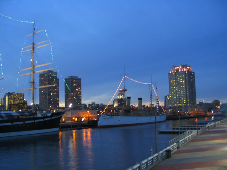 a long line of boats on the water near some buildings