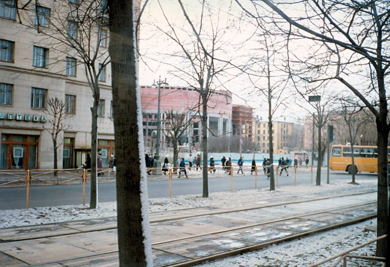 a bunch of people crossing the street in front of buildings