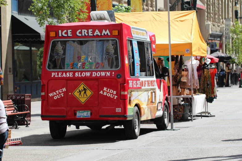 a small ice cream truck parked on a sidewalk