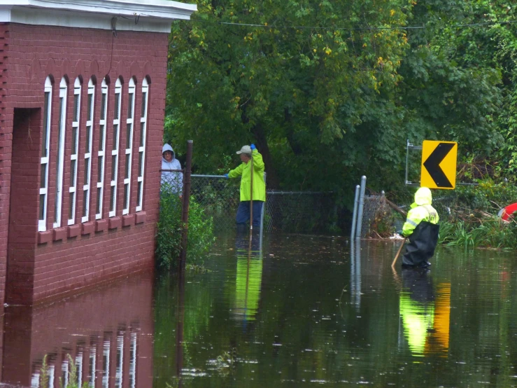 two people holding onto pole standing in water