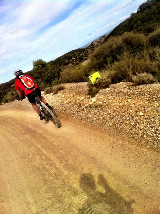 a man rides a bike down a dirt road