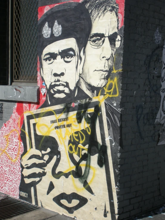 a graffiti of two men is on a wall