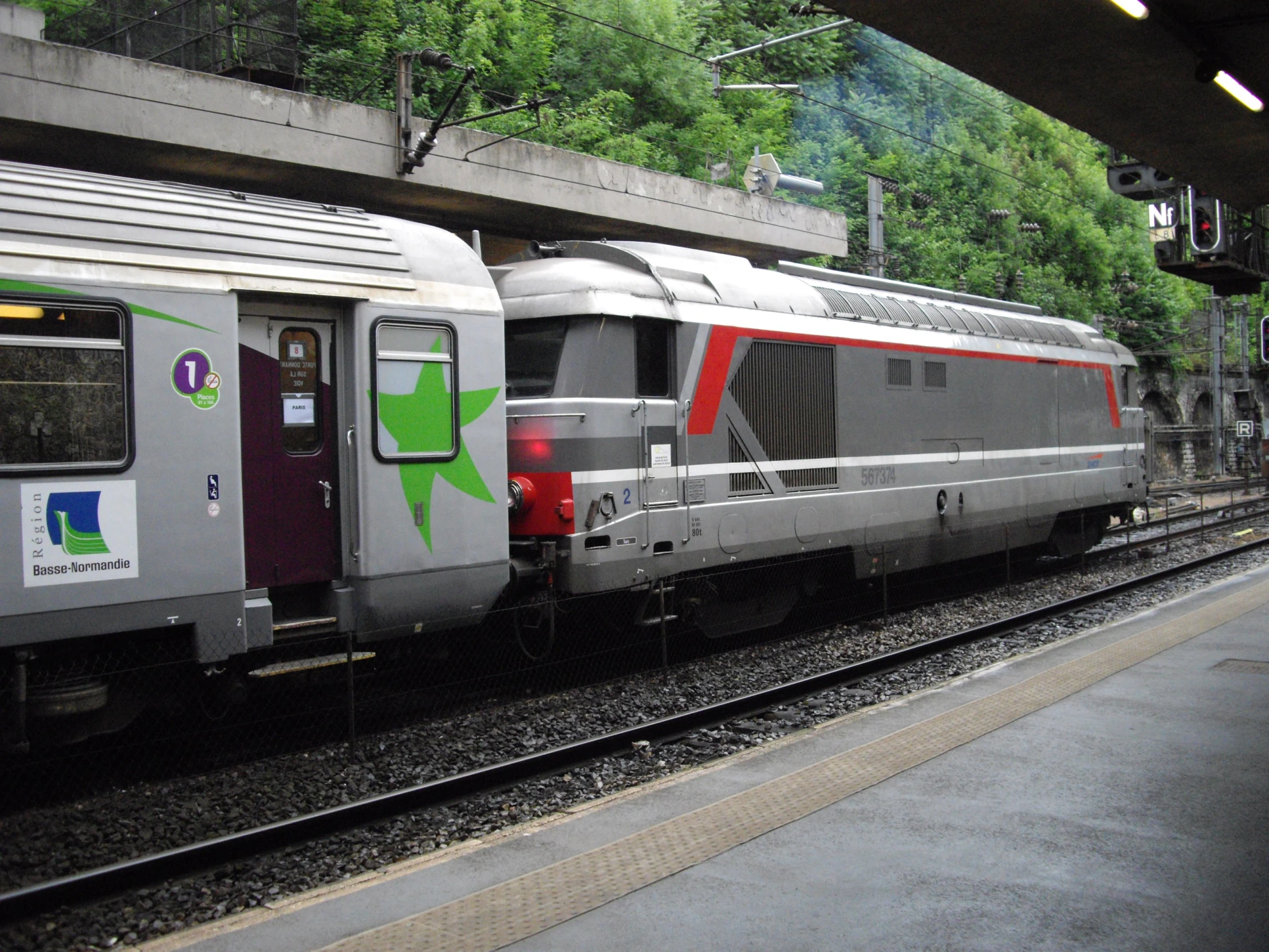 an amtrak train on the tracks in an urban station