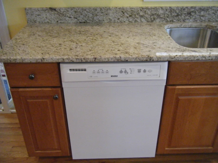 a white dishwasher sitting on a wooden counter top