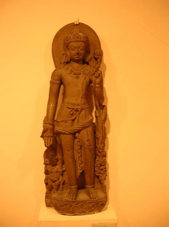 a statue made of clay with a woman sitting on top of it