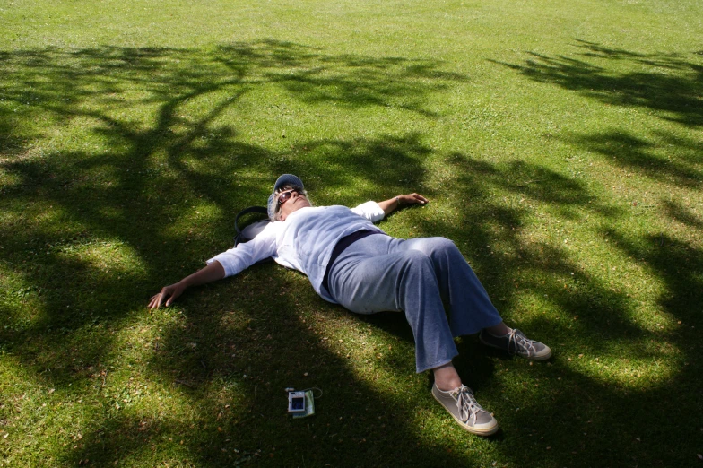 a man lays on the grass with his phone