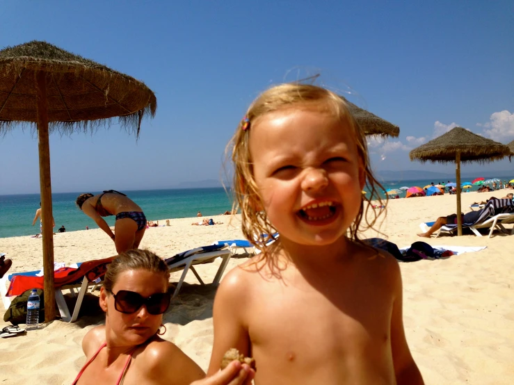 two s standing on a sandy beach with palm trees