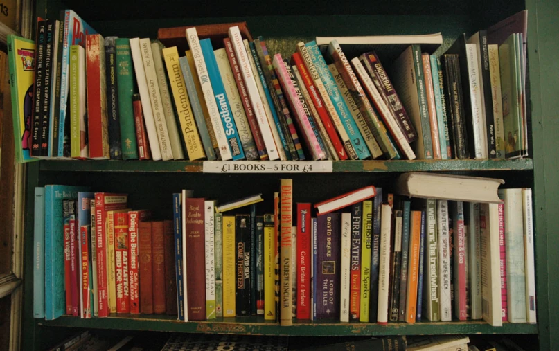 there are many books in the green book case