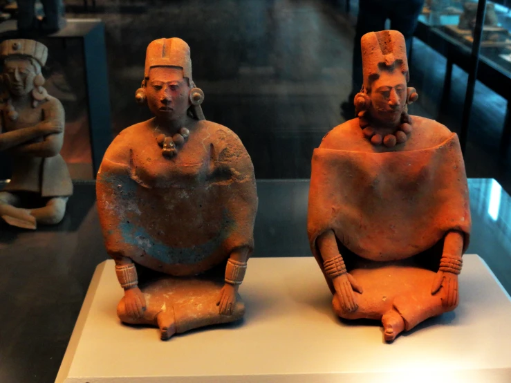 statues sitting on display in a museum exhibit